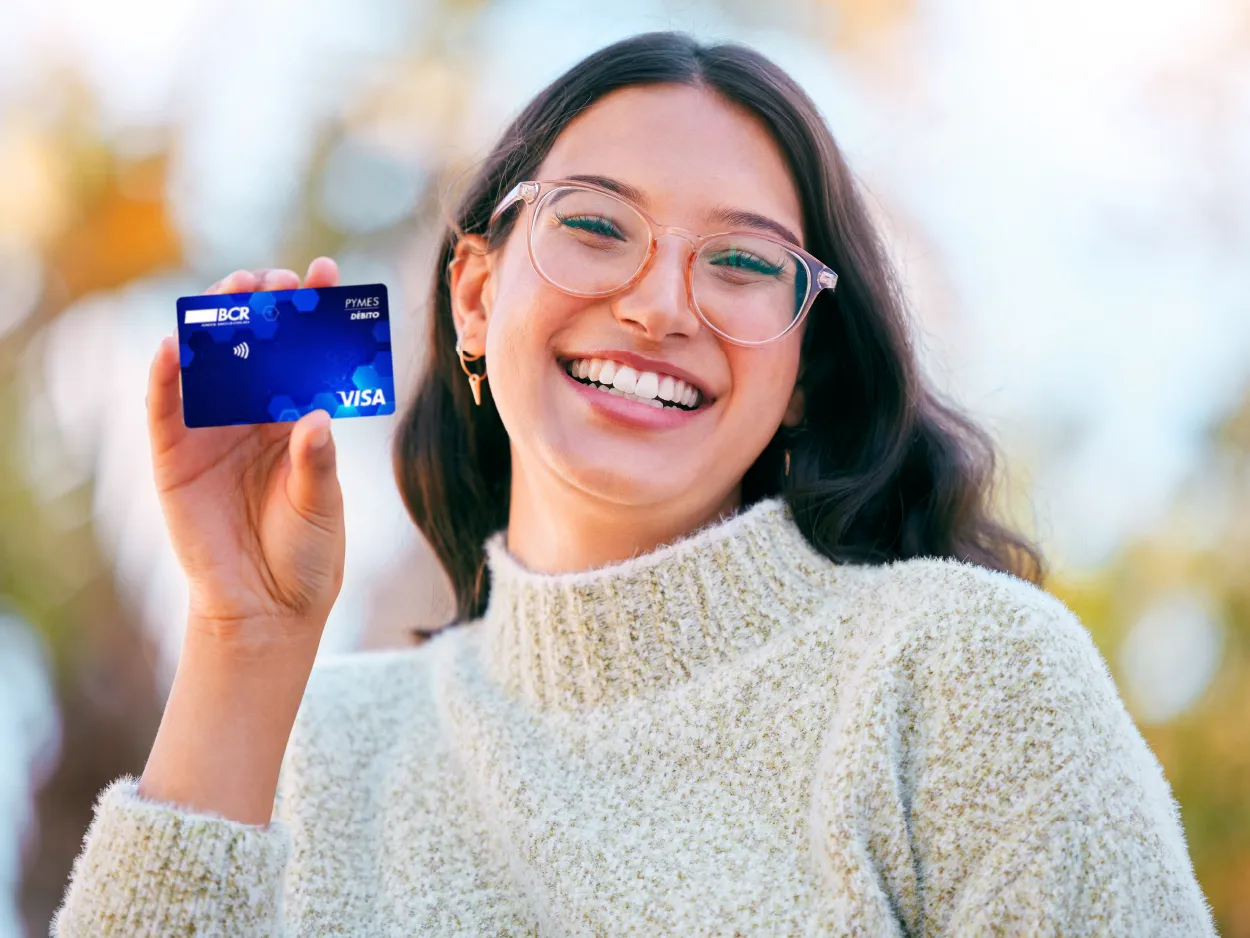 mujer sonrriente sosteniendo una tarjeta